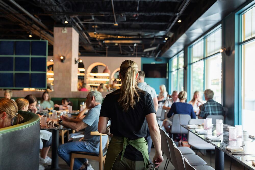 Serveuse traversant une salle de restaurant animée
