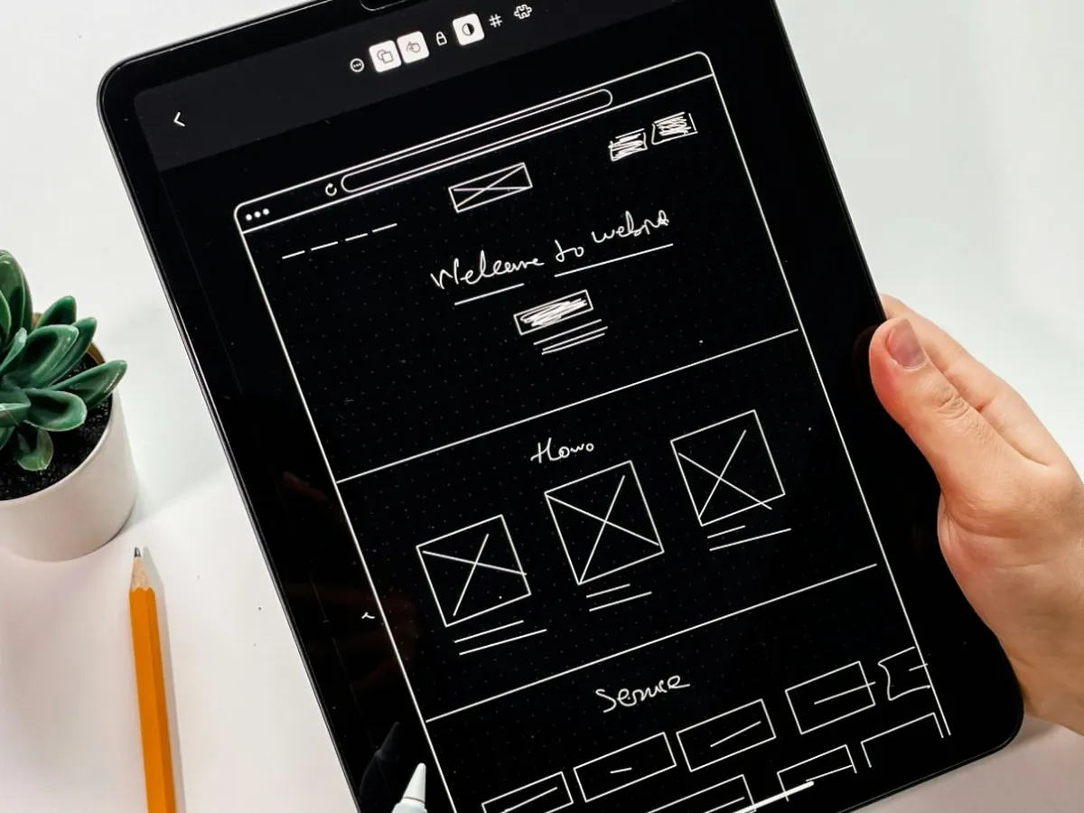 Croquis d'un site internet sur une tablette : page d'accueil, parcours et rubriques dessinés à la main