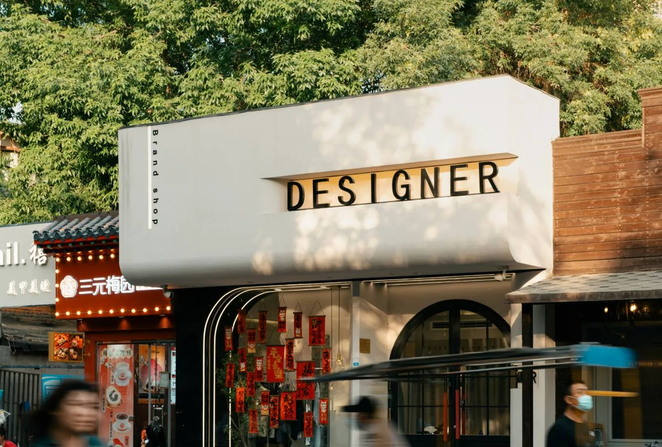 Vitrine d'une boutique de quartier avec son enseigne, devant laquelle passent des cyclistes
