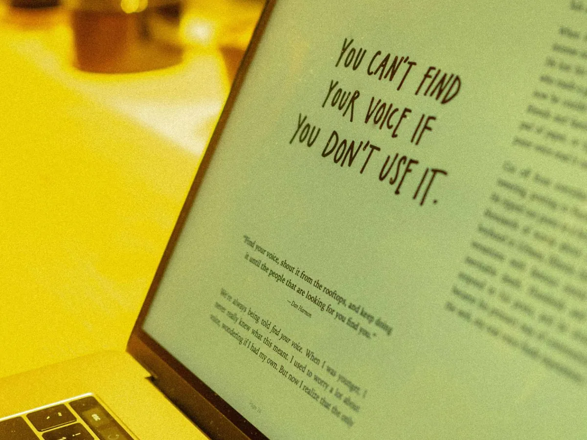 Écran d'ordinateur portable affichant la phrase « You can't find your voice if you don't use it »